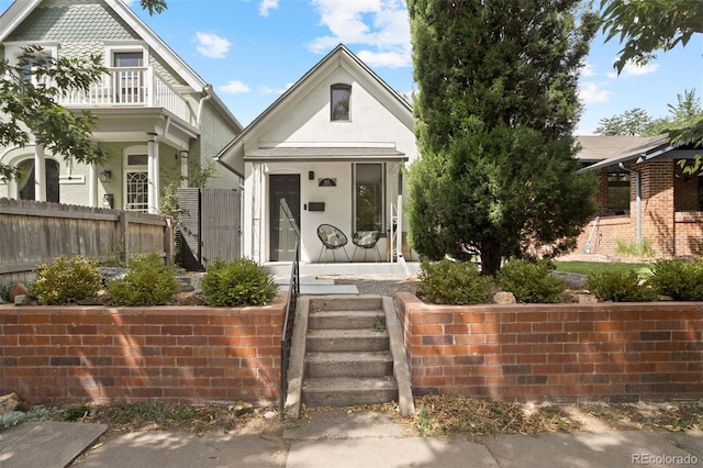 view of front facade with fence and stucco siding