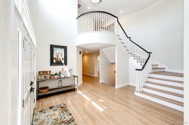 foyer with light wood-type flooring and a high ceiling