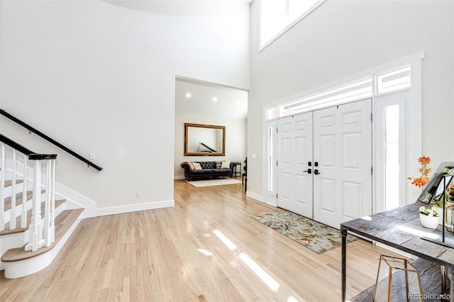 foyer entrance featuring light wood-type flooring and a high ceiling