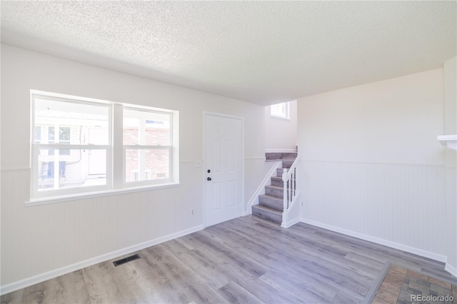 empty room featuring a textured ceiling and hardwood / wood-style floors