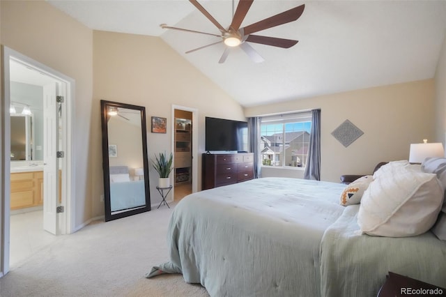 bedroom with lofted ceiling, ceiling fan, a walk in closet, light colored carpet, and connected bathroom