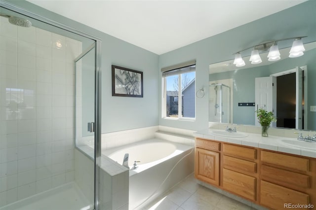 bathroom featuring a shower stall, a garden tub, tile patterned floors, and a sink