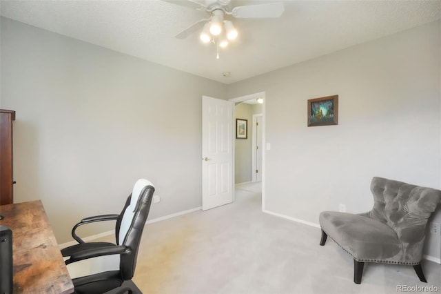 carpeted home office featuring baseboards and a ceiling fan