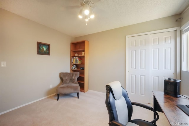 office area with baseboards, light colored carpet, a ceiling fan, and a textured ceiling