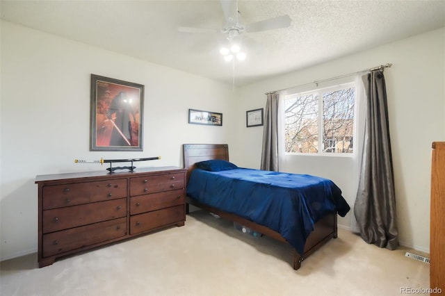 bedroom featuring visible vents, light carpet, a textured ceiling, and baseboards