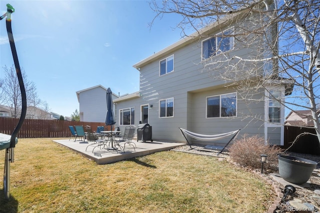 back of house with a patio area, fence, and a lawn