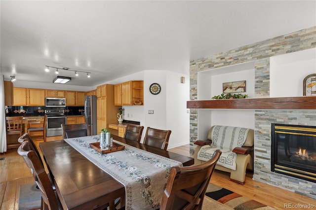 408 Sylvestor Trl, Highlands Ranch, CO 80129 - dining space with light wood-type flooring and a glass covered fireplace