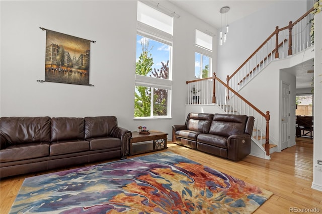 408 Sylvestor Trl, Highlands Ranch, CO 80129 - living area featuring wood finished floors, plenty of natural light, and a high ceiling