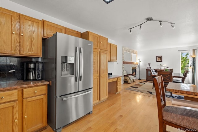 408 Sylvestor Trl, Highlands Ranch, CO 80129 - kitchen with stainless steel fridge with ice dispenser, light wood-style floors, decorative backsplash, tile counters, and brown cabinets
