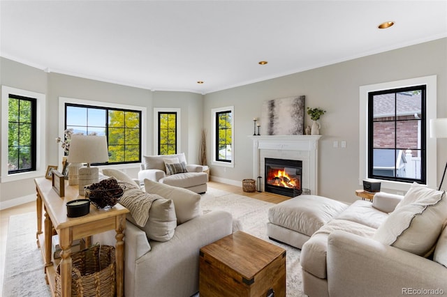 1311 Fletcher Dr, Erie, CO 80516 - living area featuring a fireplace with flush hearth, crown molding, baseboards, recessed lighting, and light wood-type flooring