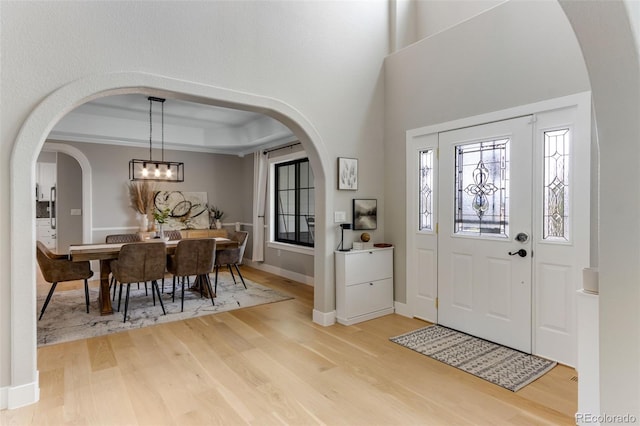 1311 Fletcher Dr, Erie, CO 80516 - foyer with wood finished floors, baseboards, arched walkways, and a chandelier