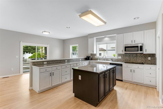 1311 Fletcher Dr, Erie, CO 80516 - kitchen with appliances with stainless steel finishes, a sink, white cabinets, light wood finished floors, and recessed lighting