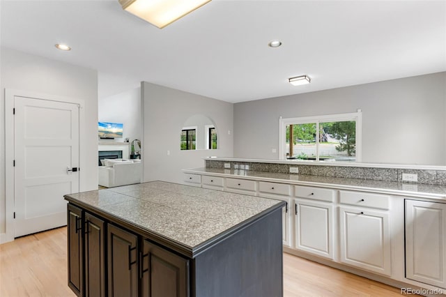 1311 Fletcher Dr, Erie, CO 80516 - kitchen featuring tile countertops, light wood finished floors, a center island, white cabinets, and recessed lighting