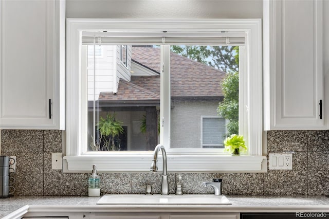 1311 Fletcher Dr, Erie, CO 80516 - kitchen view of a sink, white cabinetry, light countertops, and backsplash