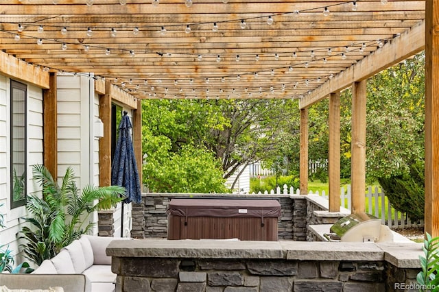 1311 Fletcher Dr, Erie, CO 80516 - view of patio featuring a hot tub, a pergola, and an outdoor kitchen