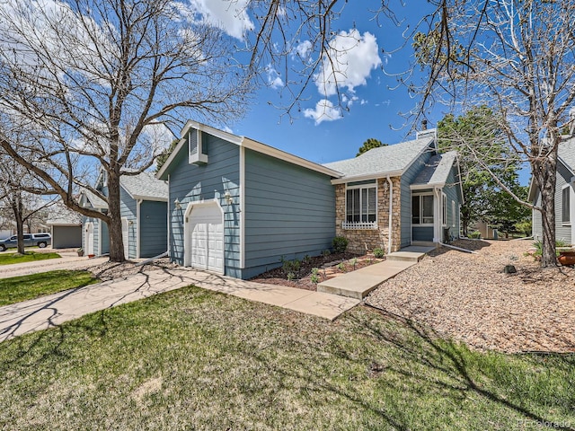 view of front of house with a front yard, stone siding, roof with shingles, and driveway