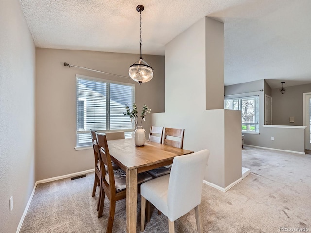 dining area with carpet floors, baseboards, and a textured ceiling