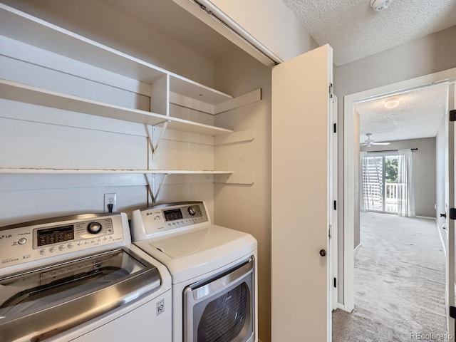 laundry room with a textured ceiling, washing machine and clothes dryer, carpet flooring, and baseboards