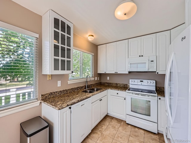 kitchen featuring white appliances, a sink, white cabinetry, glass insert cabinets, and light tile patterned floors