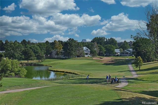 view of home's community featuring a water view, view of golf course, and a lawn