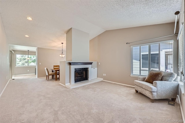 sitting room with light colored carpet, baseboards, a textured ceiling, recessed lighting, and a fireplace with raised hearth