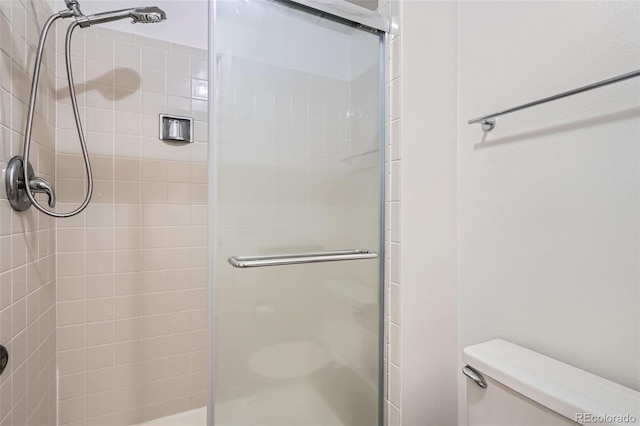 bathroom featuring a stall shower and toilet