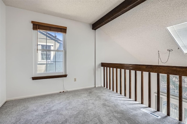carpeted empty room with a textured ceiling and baseboards