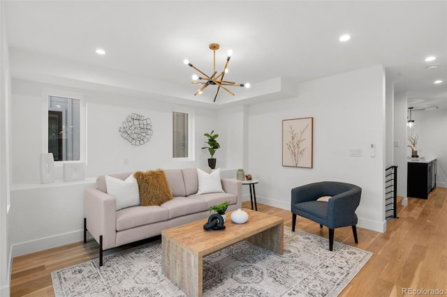living area with a chandelier, recessed lighting, light wood-style floors, and baseboards