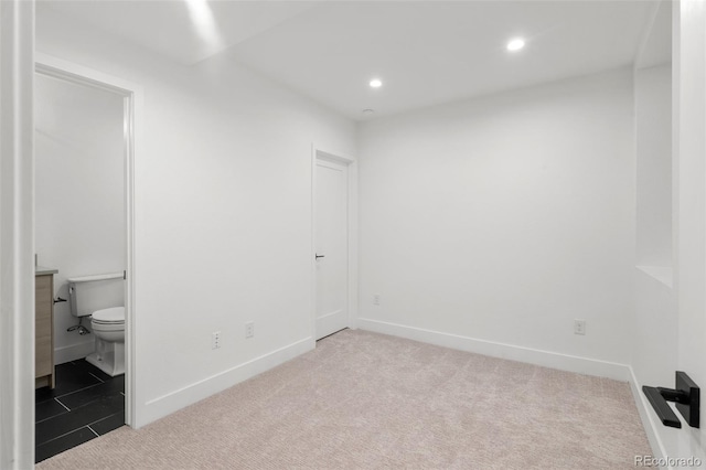 unfurnished bedroom with recessed lighting, baseboards, carpet, and ensuite bathroom