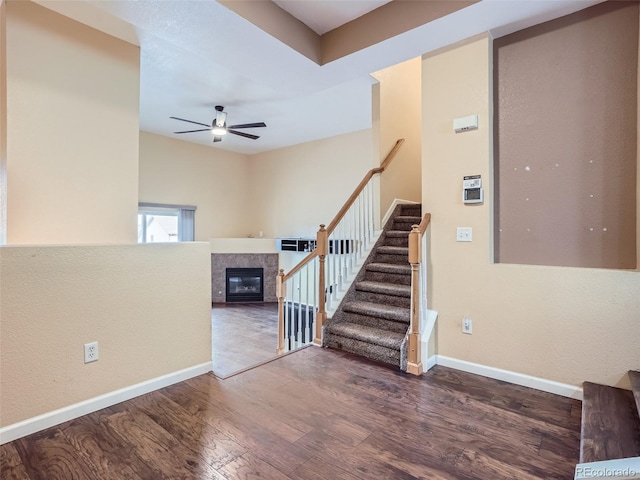 interior space featuring ceiling fan, a fireplace, and dark hardwood / wood-style floors