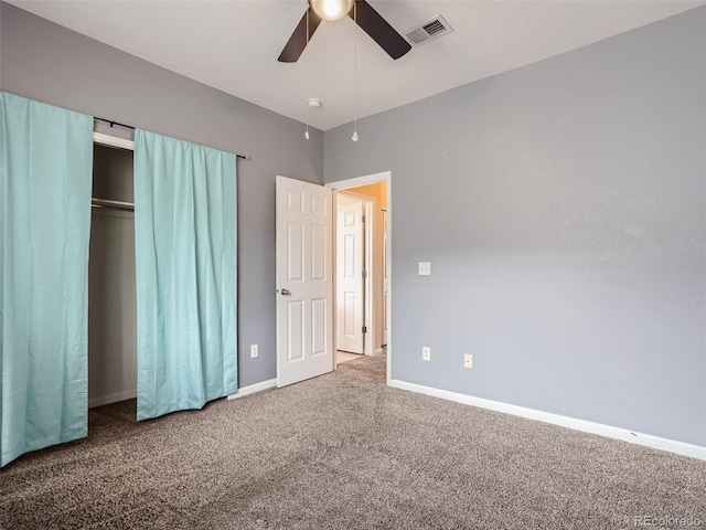 unfurnished bedroom featuring ceiling fan, a closet, and dark colored carpet