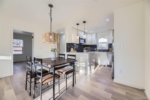 dining room featuring light wood-style floors, recessed lighting, and baseboards