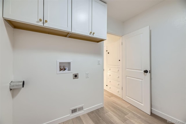 clothes washing area with cabinet space, washer hookup, electric dryer hookup, light wood-type flooring, and visible vents