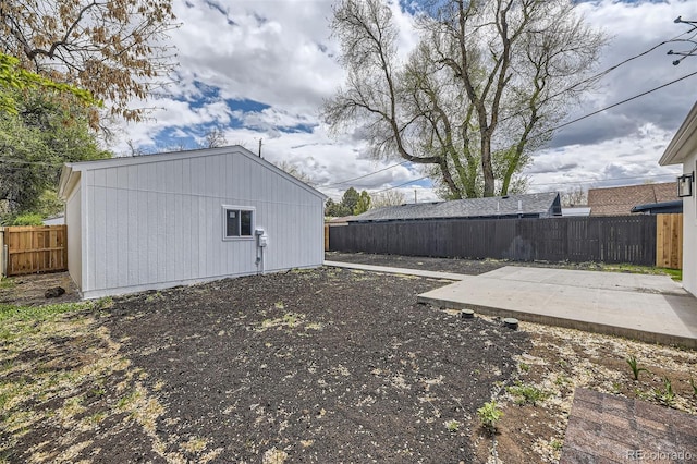 view of yard with an outbuilding, a fenced backyard, and a patio area