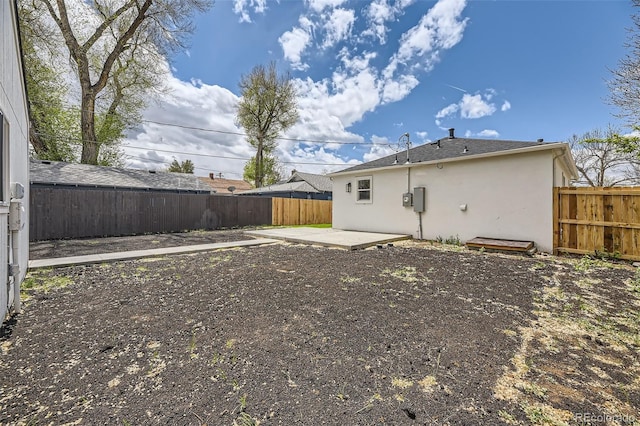 back of house featuring a patio, a fenced backyard, and stucco siding