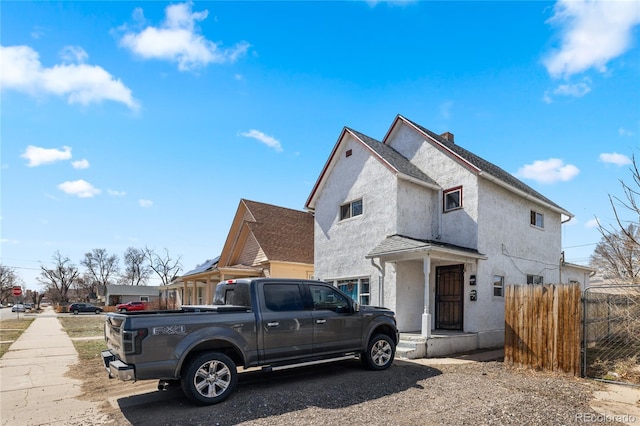 1437 Cypress St, Pueblo, CO 81004 - view of front of property featuring stucco siding, a chimney, and a shingled roof
