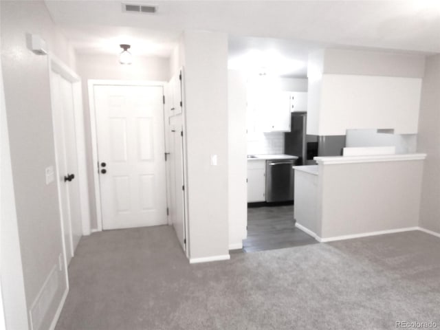 2215 S Buckley Rd Unit 201, Aurora, CO 80013 - kitchen with stainless steel dishwasher, carpet flooring, white cabinets, and baseboards