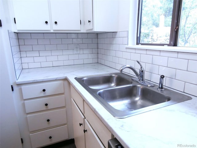 2215 S Buckley Rd Unit 201, Aurora, CO 80013 - kitchen featuring a sink, white cabinetry, decorative backsplash, and light stone counters