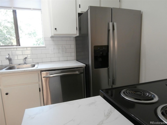 2215 S Buckley Rd Unit 201, Aurora, CO 80013 - kitchen with stainless steel appliances, a sink, tasteful backsplash, and white cabinetry