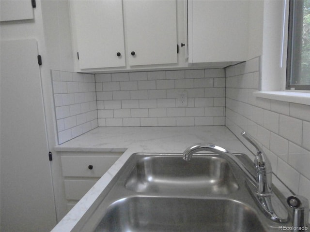 2215 S Buckley Rd Unit 201, Aurora, CO 80013 - detailed view of a sink, white cabinetry, and backsplash