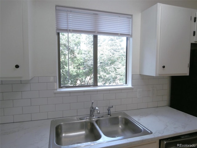 2215 S Buckley Rd Unit 201, Aurora, CO 80013 - kitchen featuring a sink, dishwashing machine, white cabinetry, and decorative backsplash