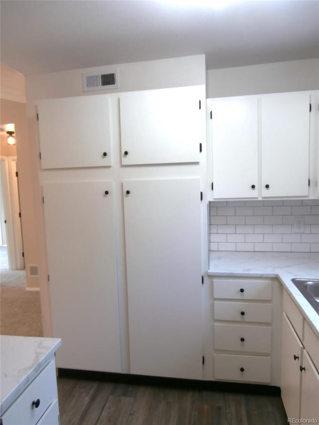 2215 S Buckley Rd Unit 201, Aurora, CO 80013 - kitchen with white cabinetry, backsplash, dark wood-style floors, light stone countertops, and a sink