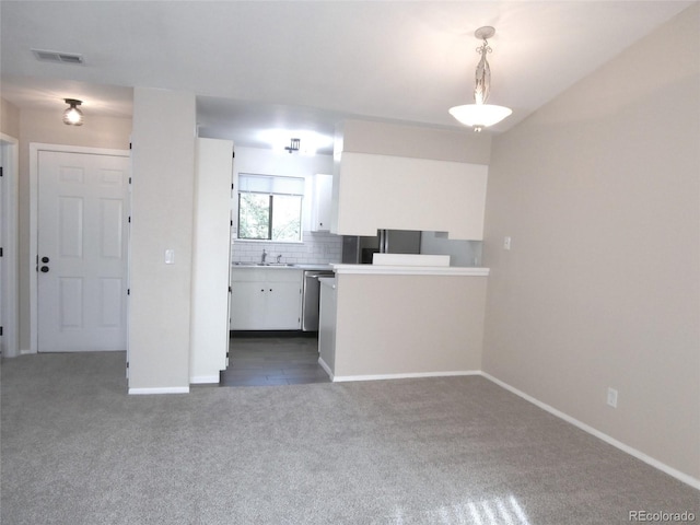 2215 S Buckley Rd Unit 201, Aurora, CO 80013 - kitchen with dark carpet, white cabinetry, a sink, light countertops, and tasteful backsplash