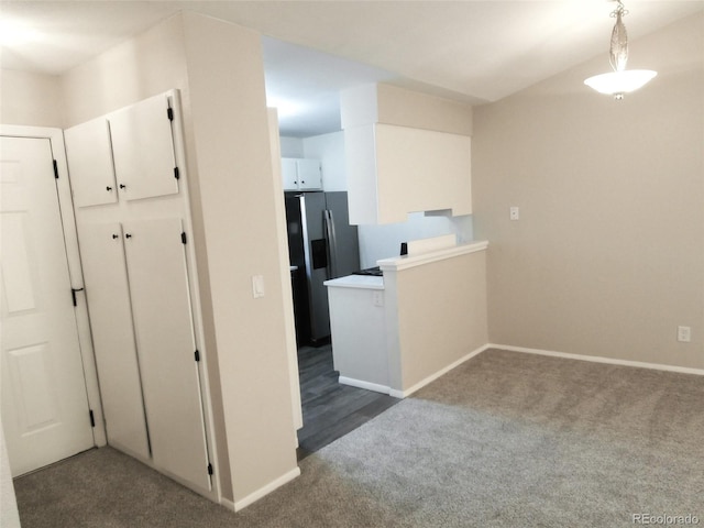 2215 S Buckley Rd Unit 201, Aurora, CO 80013 - kitchen featuring stainless steel refrigerator with ice dispenser, dark colored carpet, baseboards, and white cabinets