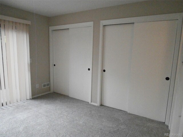2215 S Buckley Rd Unit 201, Aurora, CO 80013 - unfurnished bedroom featuring carpet and two closets