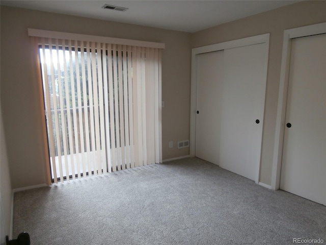 2215 S Buckley Rd Unit 201, Aurora, CO 80013 - unfurnished bedroom featuring carpet and two closets