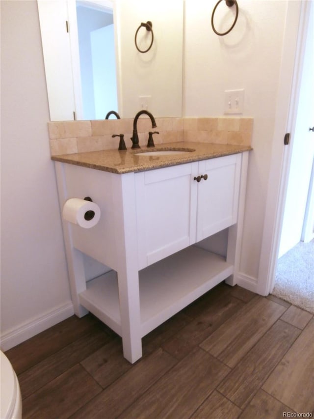 2215 S Buckley Rd Unit 201, Aurora, CO 80013 - bathroom featuring wood finished floors, vanity, toilet, and baseboards