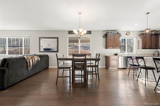 dining space with recessed lighting, baseboards, an inviting chandelier, and dark wood finished floors