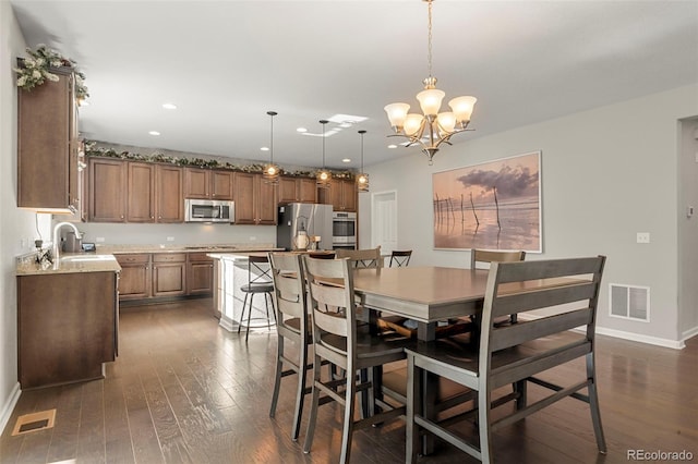 dining area featuring a chandelier, visible vents, baseboards, and dark wood-style floors