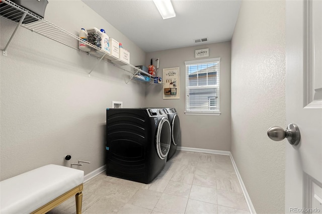 clothes washing area featuring visible vents, baseboards, washing machine and dryer, and laundry area